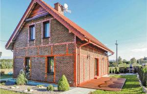a small brick house with a roof at Amazing Home In Izbica With 3 Bedrooms, Wifi And Outdoor Swimming Pool in Kluki
