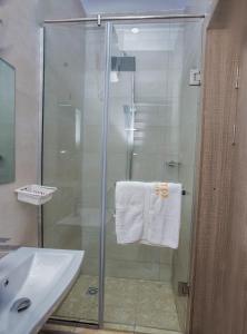 a bathroom with a glass shower with a sink at MITOS LUXURY SUITES (BODE THOMAS) in Lagos
