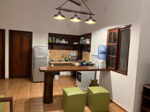 cocina con mesa de madera y taburetes verdes en Cómoda Cabaña en Buena Vista -Santa Cruz, en Buena Vista