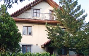 a house with a balcony and trees in front of it at Awesome Home In Darlowo With Kitchen in Darłowo