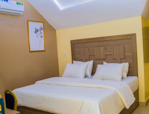 a bedroom with a large bed with white pillows at MITOS LUXURY SUITES (BODE THOMAS) in Lagos
