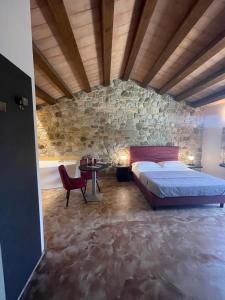 een slaapkamer met een bed en een stenen muur bij Modus Aquae in Brisighella