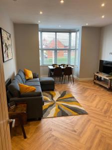 a living room with a couch and a table at Stylish 2 Bed Apt, 2 Minute Walk From The Beach. in Sheringham