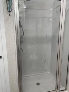 La salle de bains est pourvue d'une douche avec une porte en verre. dans l'établissement Surfside Beachfront Luxe, à Surfside Beach