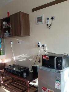a kitchen with a microwave on top of a refrigerator at Mkombodzi Global Homes in Mtwapa