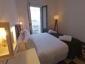 una camera da letto con un grande letto bianco e una finestra di Civico 34, casa tipica salentina a Ortelle