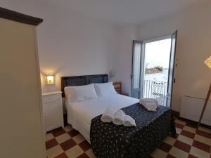 Civico 34, casa tipica salentina في Ortelle: غرفة نوم مع سرير مع منشفتين على طاولة