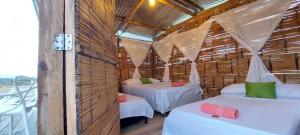 Habitación con 2 camas en una cabaña de paja en Hotel Flor de Liz Bereshit Bara en Villavieja