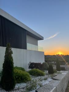 um edifício de escritórios com um pôr-do-sol ao fundo em Habitación deluxe rodeada de viñedos em Ribadumia