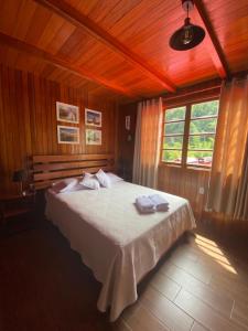 a bedroom with a large bed in a wooden room at HAUS KÖHEL HOSPEDAJE POZUZO in Pozuzo