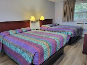 a hotel room with two beds and a window at Knights Inn Cobourg in Cobourg