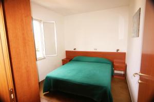 una camera da letto con un letto verde e una finestra di Village GEMINI a Peschici