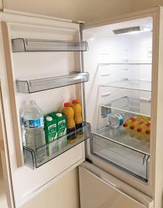 - un réfrigérateur ouvert avec des bouteilles d'eau et des jus de fruits dans l'établissement Reims Saint-Remi, à Reims