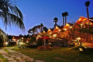 a resort with a picnic table and lights at night at Jungmun Log Pension & Resort in Seogwipo
