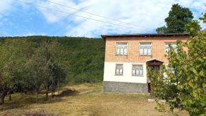 a brick house in the middle of a field at Sholedani in Ambrolauri
