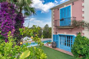 une villa avec une piscine et des fleurs dans l'établissement Casa Colonial Sitges Hills, à Olivella