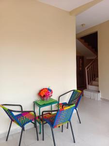 a table with two chairs and a bowl of flowers on it at Résidence Les Fleurettes in Bamako