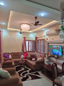 a living room with couches and a flat screen tv at Résidence Les Fleurettes in Bamako