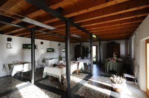 comedor con mesas y sillas blancas y techos de madera en Country House Due Fiumi, en Sacile