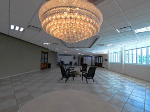 un grand lustre dans une pièce avec une table et des chaises dans l'établissement Costa Bahia Hotel, Convention Center and Casino, à Guayanilla