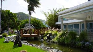 a bridge over a river in front of a house at Costa Bahia Hotel, Convention Center and Casino in Guayanilla