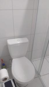 ein weißes WC in einem weiß gefliesten Bad in der Unterkunft Sun Way 1408 in Ubatuba