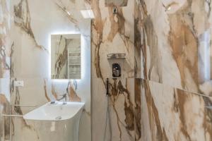 a bathroom with a sink and a mirror at Aldrovandi Luxury Suites and Apartment in Bologna +24 photos