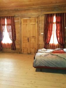 a bedroom with two beds and two windows at Sholedani in Ambrolauri