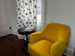 einen gelben Stuhl und einen Tisch in einem Zimmer in der Unterkunft Hollingsworth Guest House With Pool in Lakeland