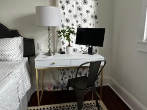 a desk with a computer and a chair in a bedroom at Hollingsworth Guest House With Pool in Lakeland