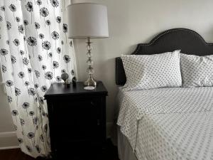 1 dormitorio con cama y mesita de noche con lámpara en Hollingsworth Guest House With Pool, en Lakeland