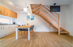 kuchnia i jadalnia z drewnianym stołem i schodami w obiekcie Cozy Home In Rewal With Kitchen w Rewalu