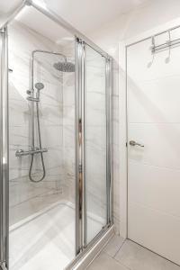 y baño con ducha y puerta de cristal. en Sand Club Helen , 256, Golf del Sur Tenerife , España en San Miguel de Abona