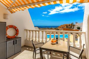 een balkon met een tafel en uitzicht op het strand bij Sand Club Helen , 256, Golf del Sur Tenerife , España in San Miguel de Abona