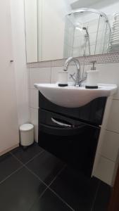 a bathroom with a white sink and a mirror at Apartament Przy Starówce - Bella in Bolesławiec