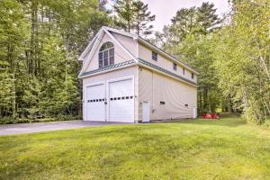 a white house with a garage on a yard at Readfield Retreat with Lake Maranacook Views! in Readfield