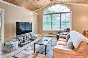 a living room with a couch and a tv at Readfield Retreat with Lake Maranacook Views! in Readfield