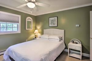 a bedroom with a white bed and a ceiling fan at Readfield Retreat with Lake Maranacook Views! in Readfield