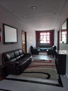 ein Wohnzimmer mit einem Ledersofa und einem Teppich in der Unterkunft La bananeraie in Tamri