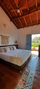 1 dormitorio con 1 cama grande y techo de madera en Casa Guatí, en Barichara