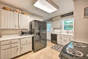 a kitchen with white cabinets and a stainless steel refrigerator at Peaceful Home with Patio and Fire Pit on 2 Acres! in Dauphin