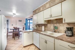 a kitchen with white cabinets and a sink and a table at San Antonio Home with Yard, 7 Mi to SeaWorld! in San Antonio