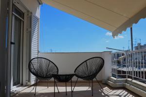 two chairs on a balcony with a view at Penthouse with Acropolis View in Athens