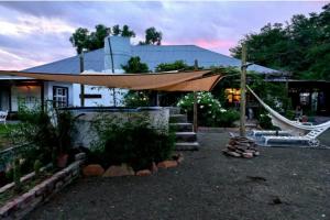 a house with a hammock in front of it at Koekeloer Selfcatering Cottages in Nieu-Bethesda