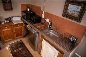 a small kitchen with a sink and a stove at Koekeloer Selfcatering Cottages in Nieu-Bethesda