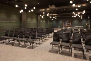 an empty auditorium with black chairs and a stage at Scandic Helsfyr in Oslo