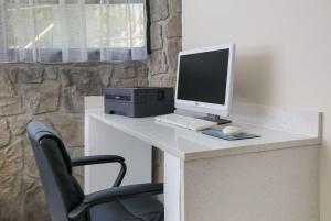 a desk with a computer monitor and a keyboard and mouse at SureStay Plus Hotel by Best Western Gatlinburg in Gatlinburg