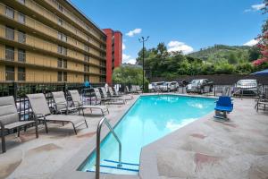 a swimming pool with chairs and a hotel at SureStay Plus Hotel by Best Western Gatlinburg in Gatlinburg