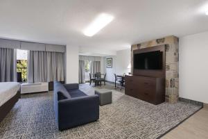 a hotel room with a bed and a tv and a couch at SureStay Plus Hotel by Best Western Gatlinburg in Gatlinburg