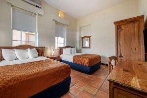 una camera d'albergo con due letti e un tavolo di Mayaguez Plaza Hotel; SureStay Collection by Best Western a Mayaguez